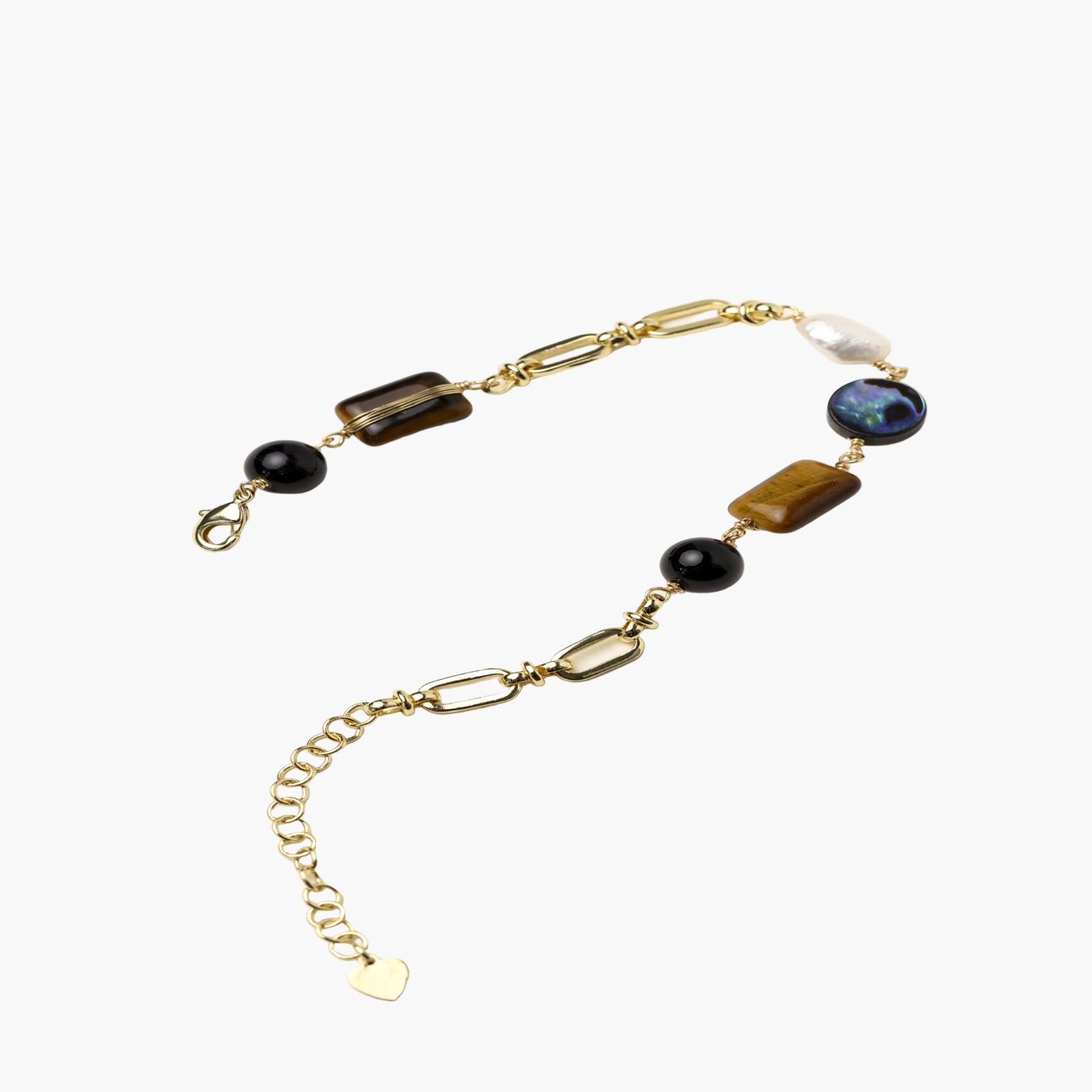 Gold chain bracelet with tiger's eye, obsidian, pearl, and iridescent abalone stones on cream background.